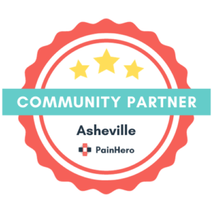 A circular badge with a red scalloped edge and a teal band in the middle labeled "COMMUNITY PARTNER." Inside the badge are three yellow stars at the top and the text "Asheville PainHero" in the center with a small cross icon, representing their dedication to physical therapy excellence.
